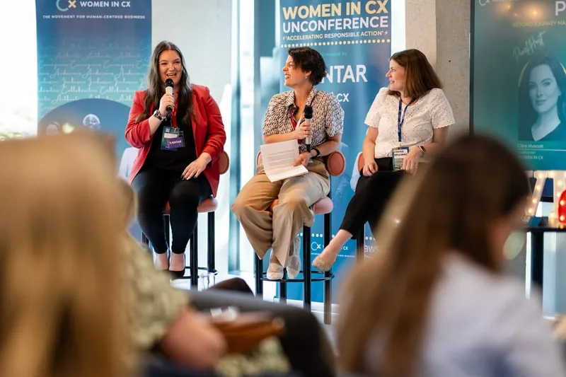 Lorena Lovric speaking into a microphone on a panel at the Women in CX Unconference